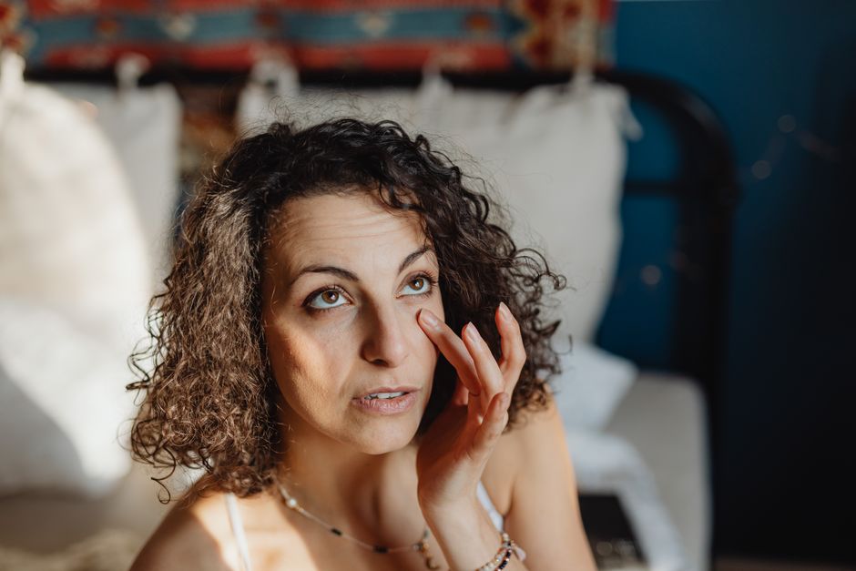 Žena nanosi njegu kože u sunčanoj sobi