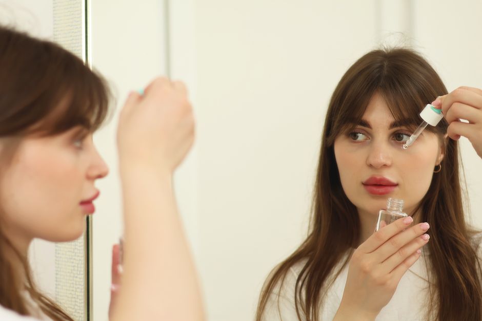 Žena nanosi serum za njegu kože